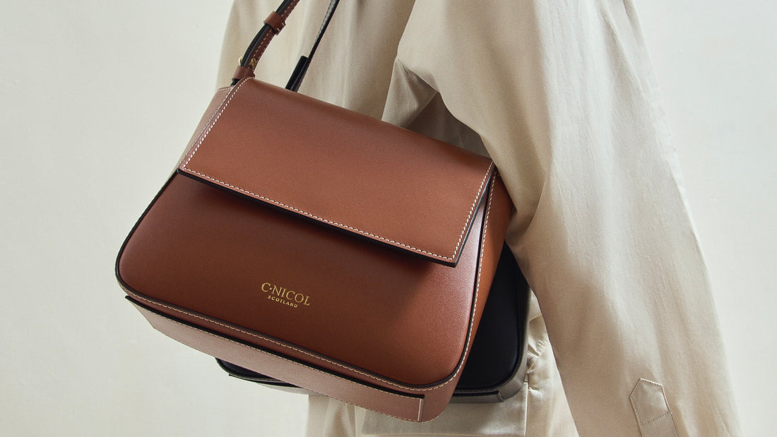 A tan C.Nicol shoulder bag pictured on a person from the side