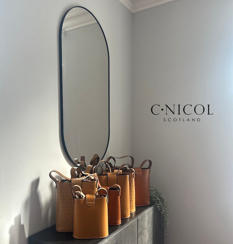 CNicol Showroom featuring C.Nicol Scotland Logo an Oval Mirror with the sun beaming down onto various Holly Mini and Maxi Brown Leather Bags 