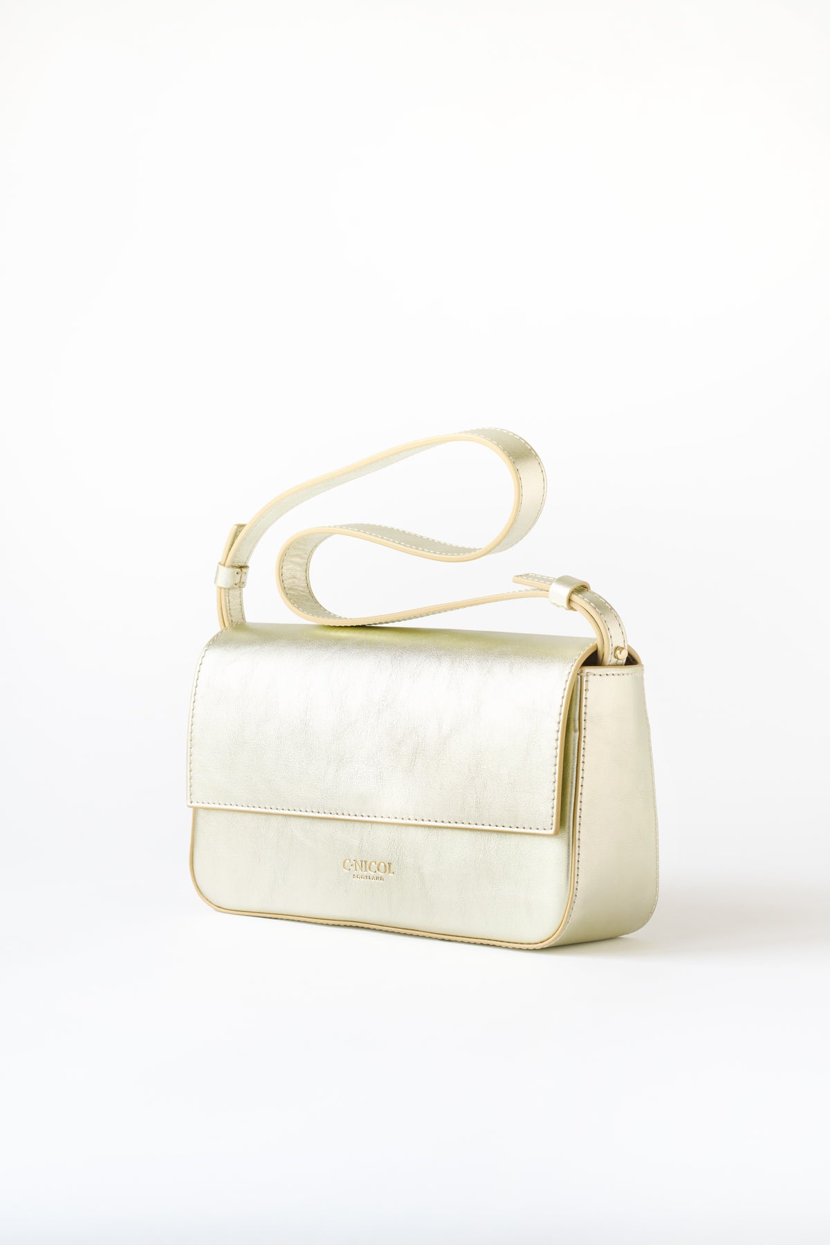 Side view of a C.Nicol Scotland metallic leather handbag, with an adjustable strap and gold detailing, pictured on a white background