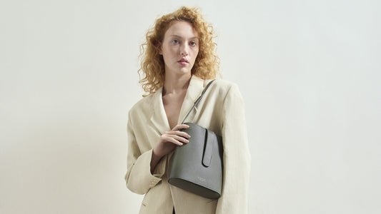 A person holding the Holly 2.0 bucket bag in pine.