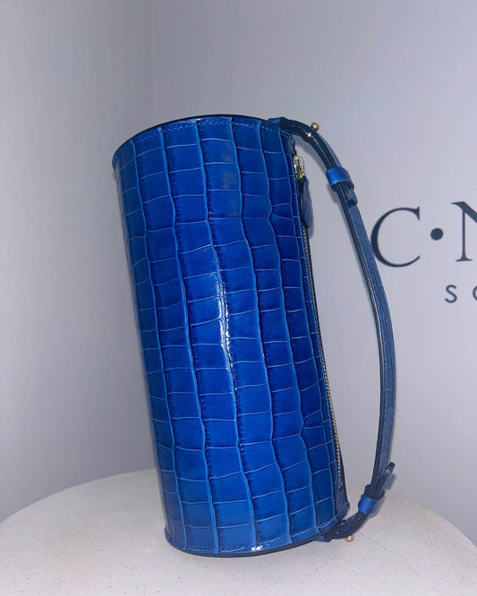 CNicol Blue Croc Leather Evie Bag Standing up on its side on White Base