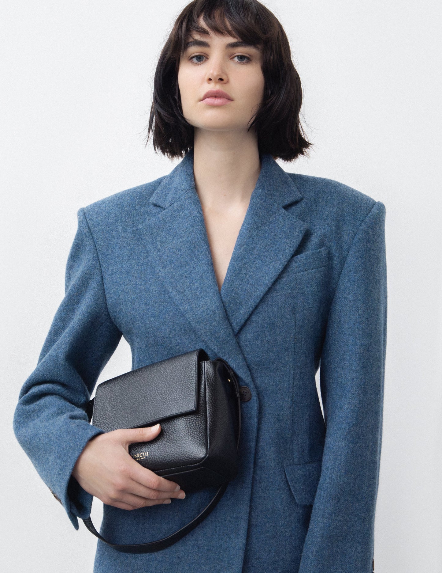 CNicol Black Leather Fia Bag held by woman in blue Blazer