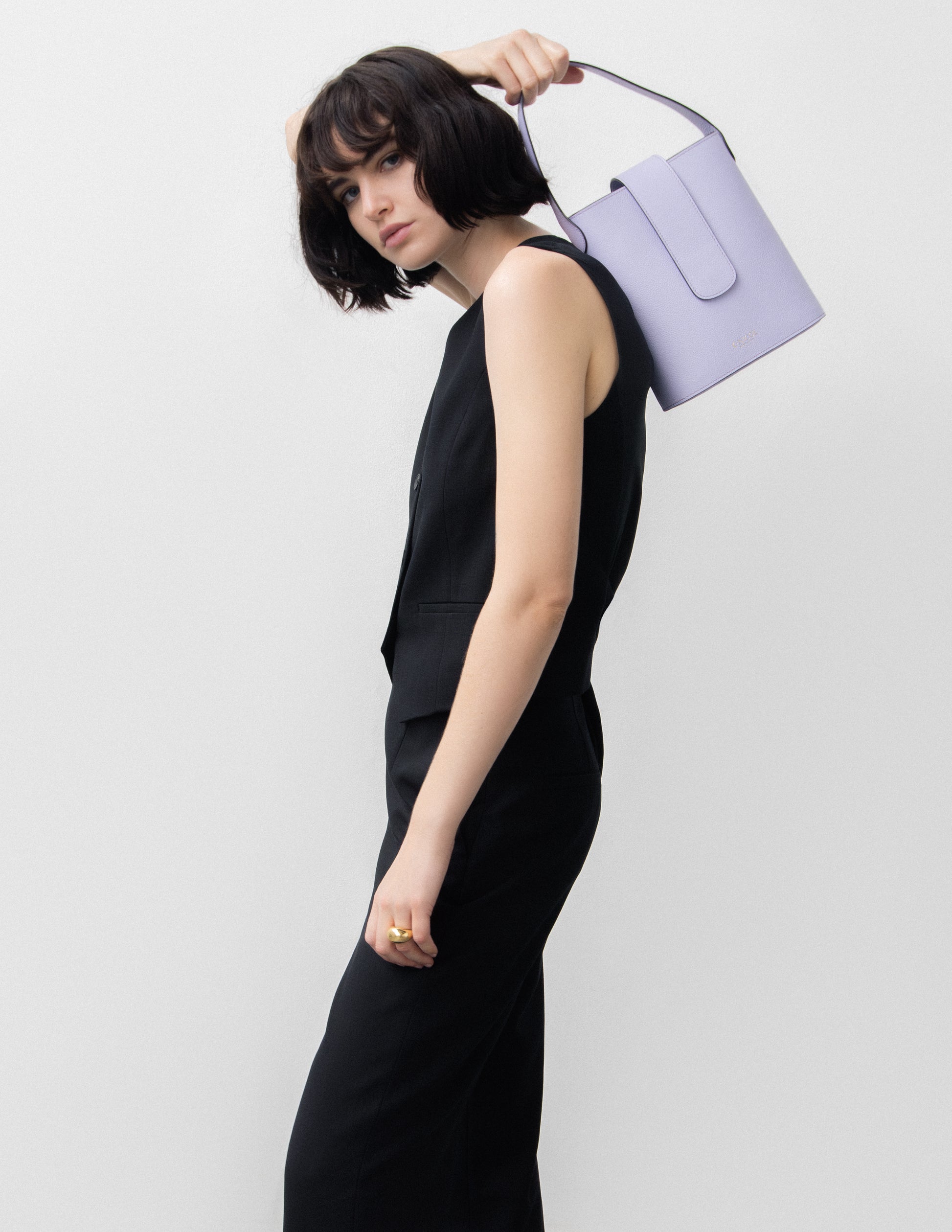 CNicol Lilac Leather Holly Bag held by Model in all Black with Bag slung over right Shoulder
