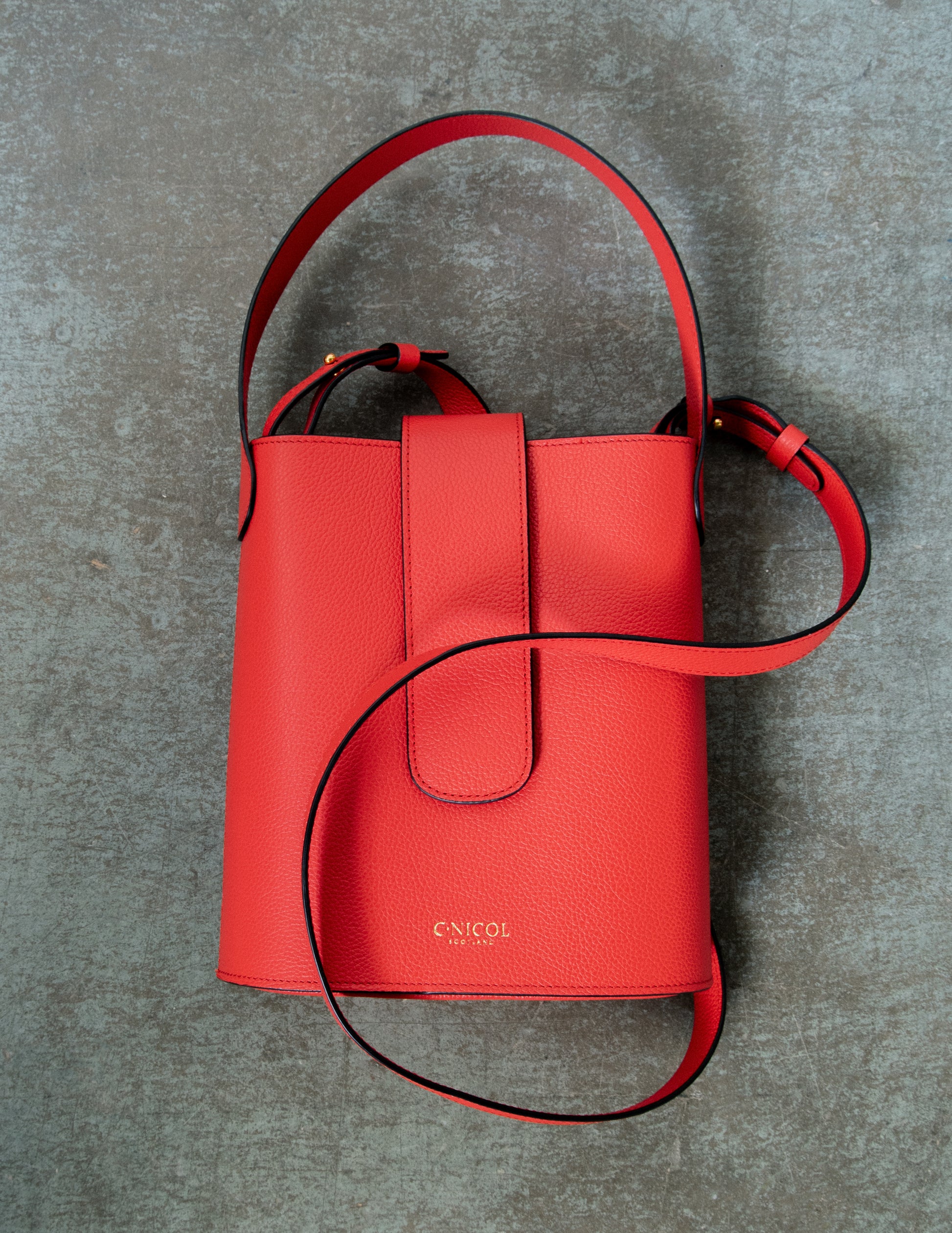 CNicol Red Leather Holly Bag against Grey Textured Background