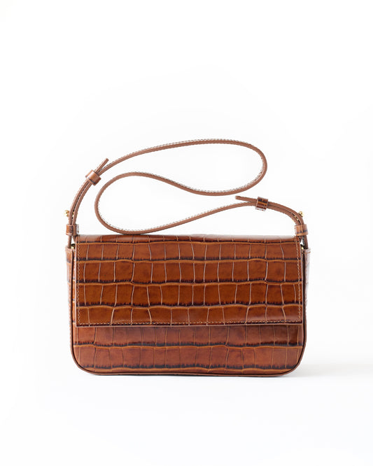 Brown crocodile-patterned handbag on a white background