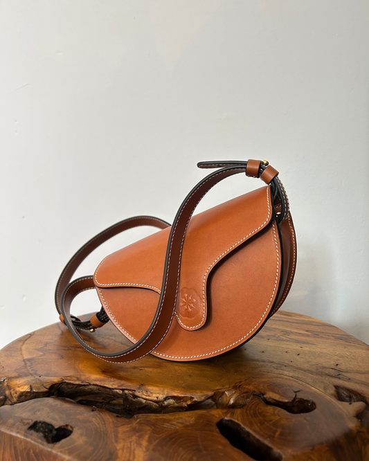 CNicol Brown Leather Lily Bag on top of brown wooden base